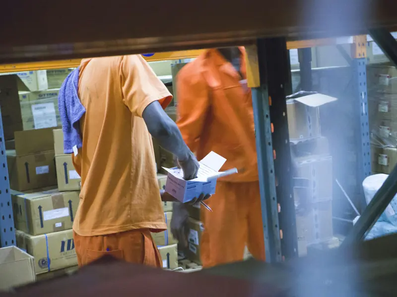 Two workers checking boxes on warehouse shelving in Entebbe, Uganda